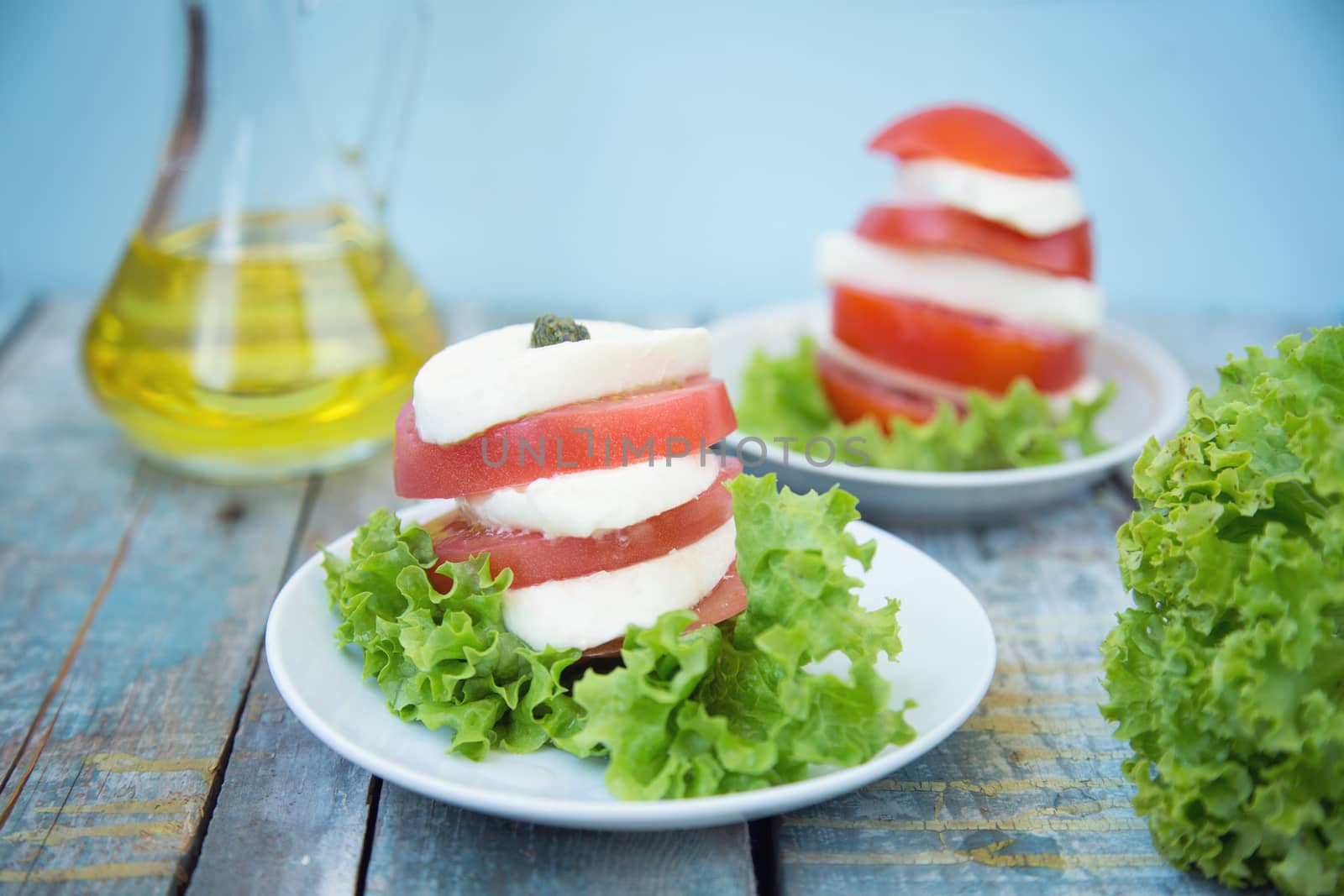 salad with mozzarella,tomatoes,dark basil on wooden retro background