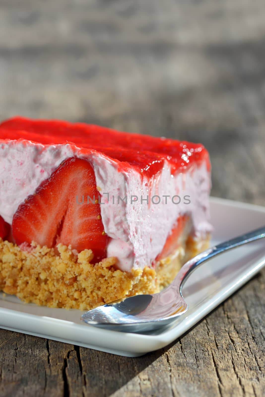 slice of strawberry cheesecake on wooden table