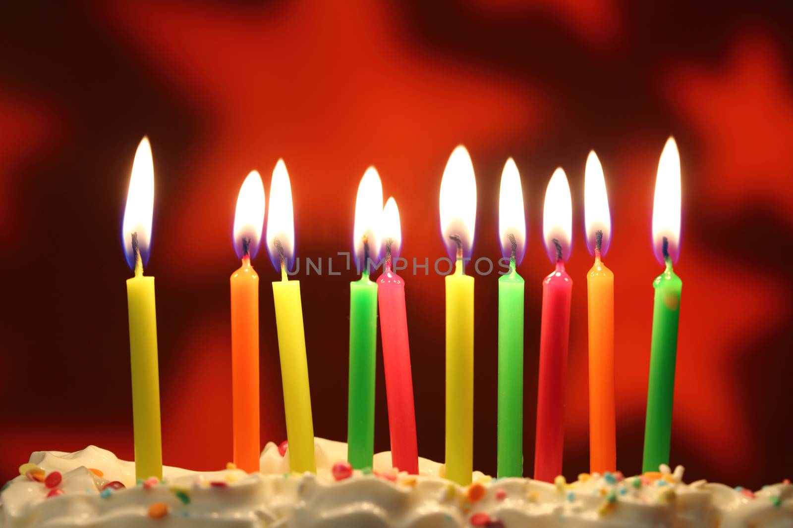 Ten lit birthday candles close up, shallow dof