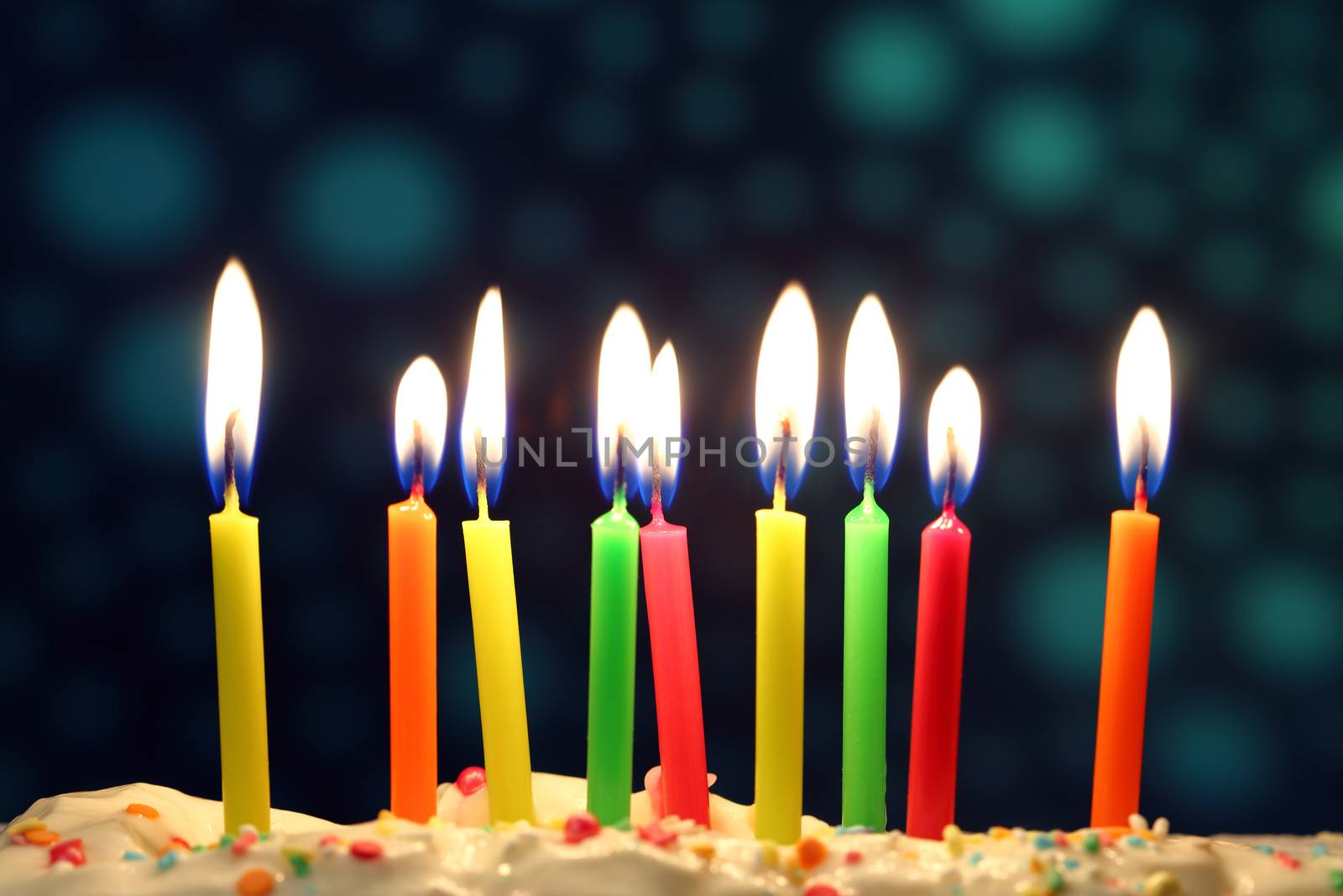 Nine lit birthday candles close up, shallow dof