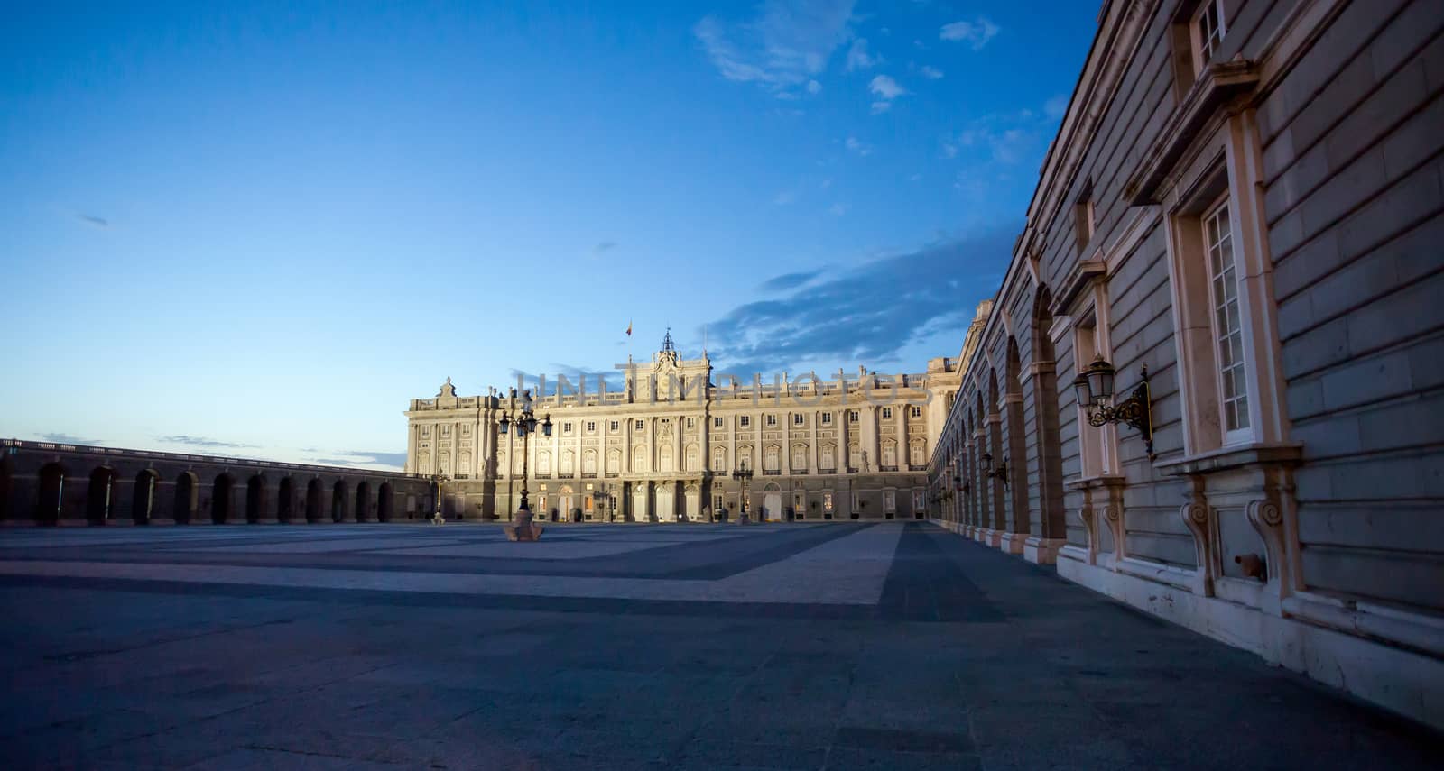 Madrid, Spain - May 6, 2012: Royal palace with tourists illuminated on spring night in Madrid, Spain