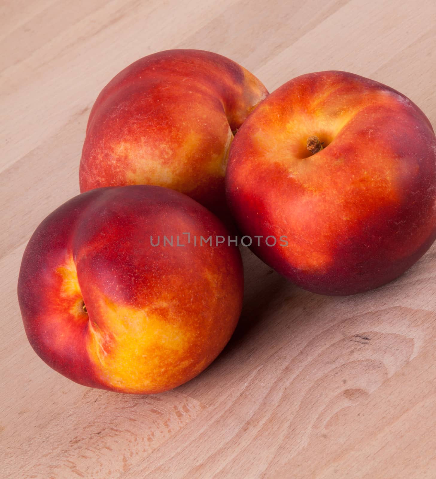 Three tasty fresh ripe juicy nectarines on white painted wooden boards for a healthy snack and diet