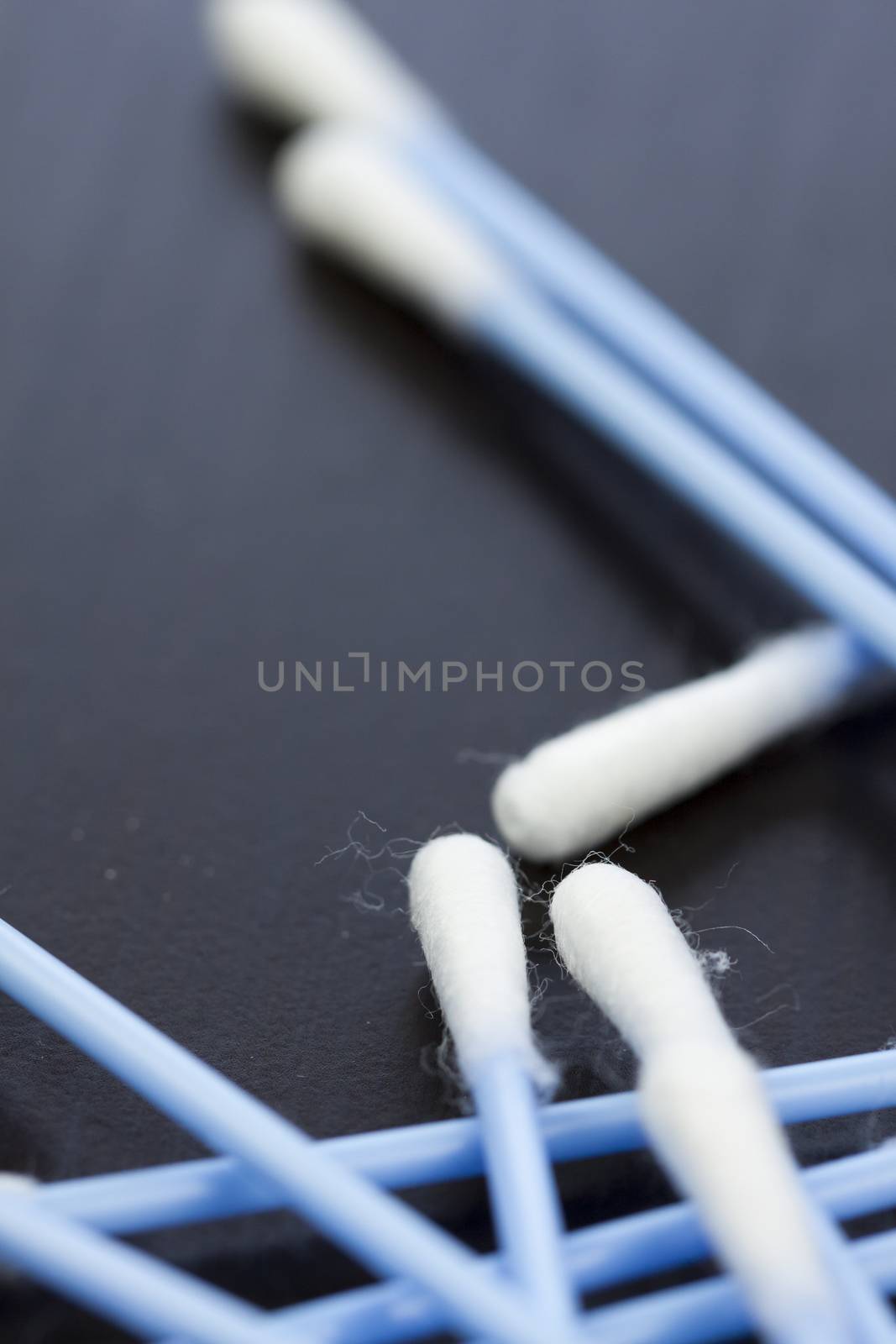 Random pile of blue plastic cotton ear buds for cleaning wax out of the ear in a health and hygiene concept