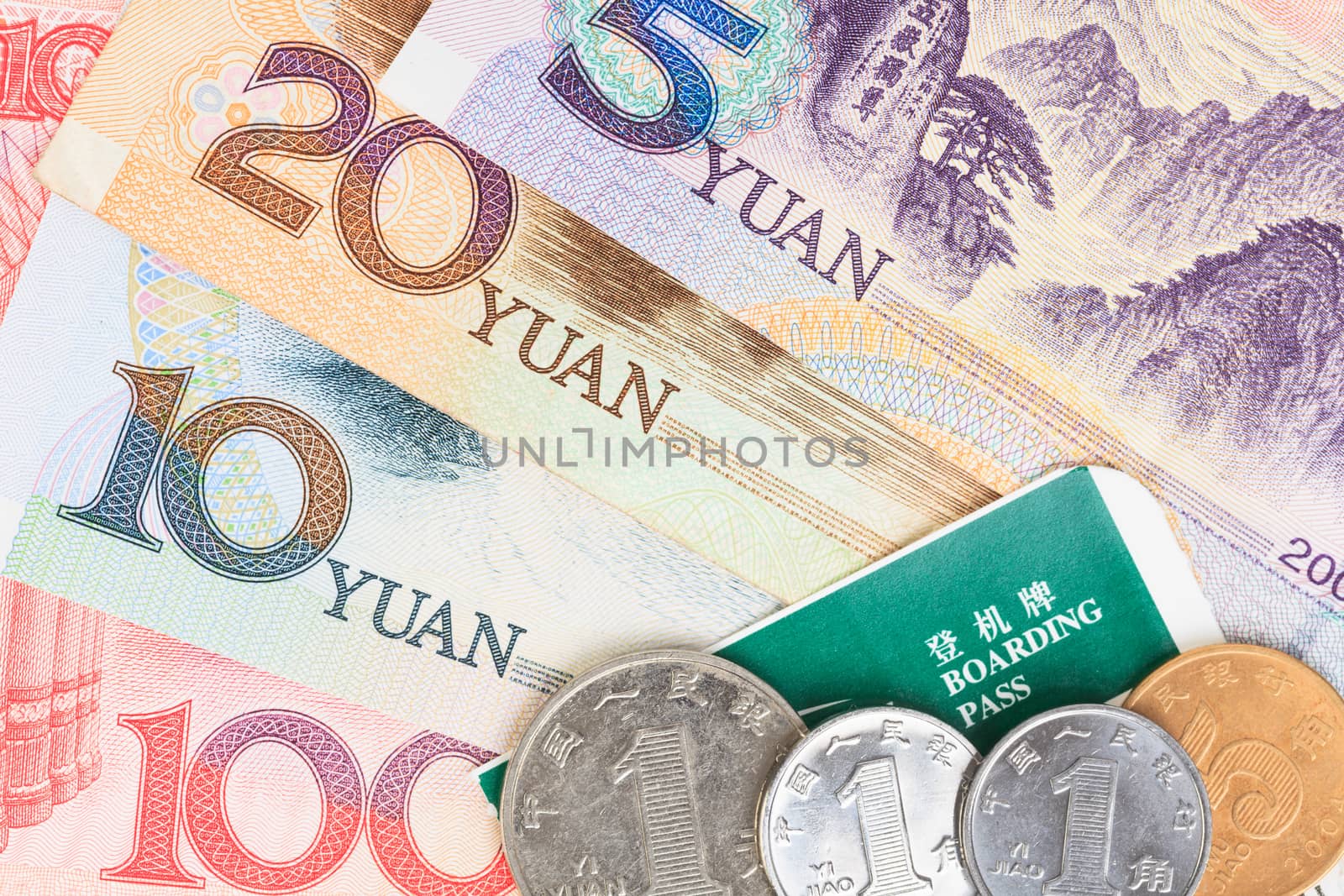 Chinese or Yuan banknotes money and coins from China's currency with boarding pass visa for travel concept, close up view as background