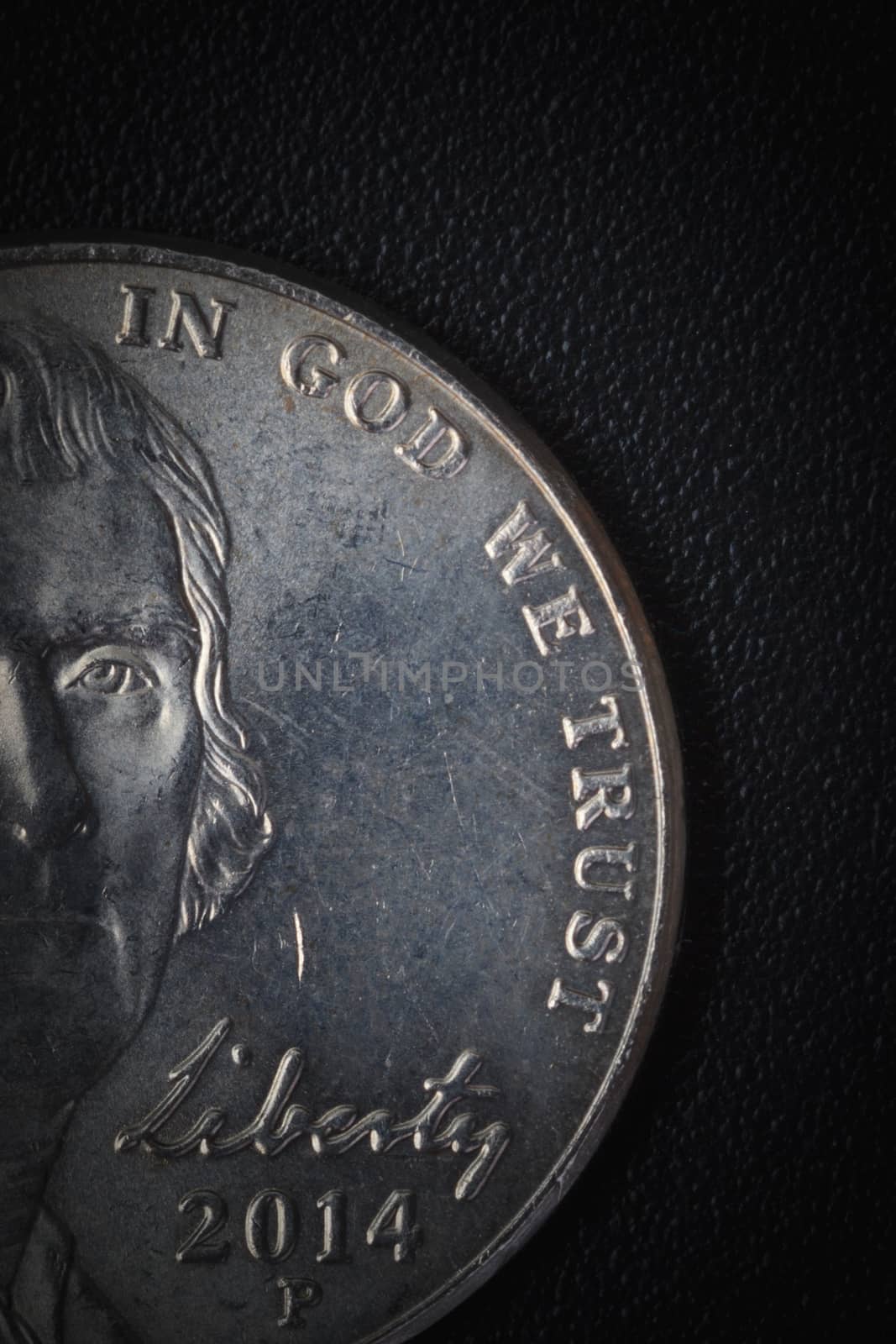 US American coin with wording "in God we trust" on black background