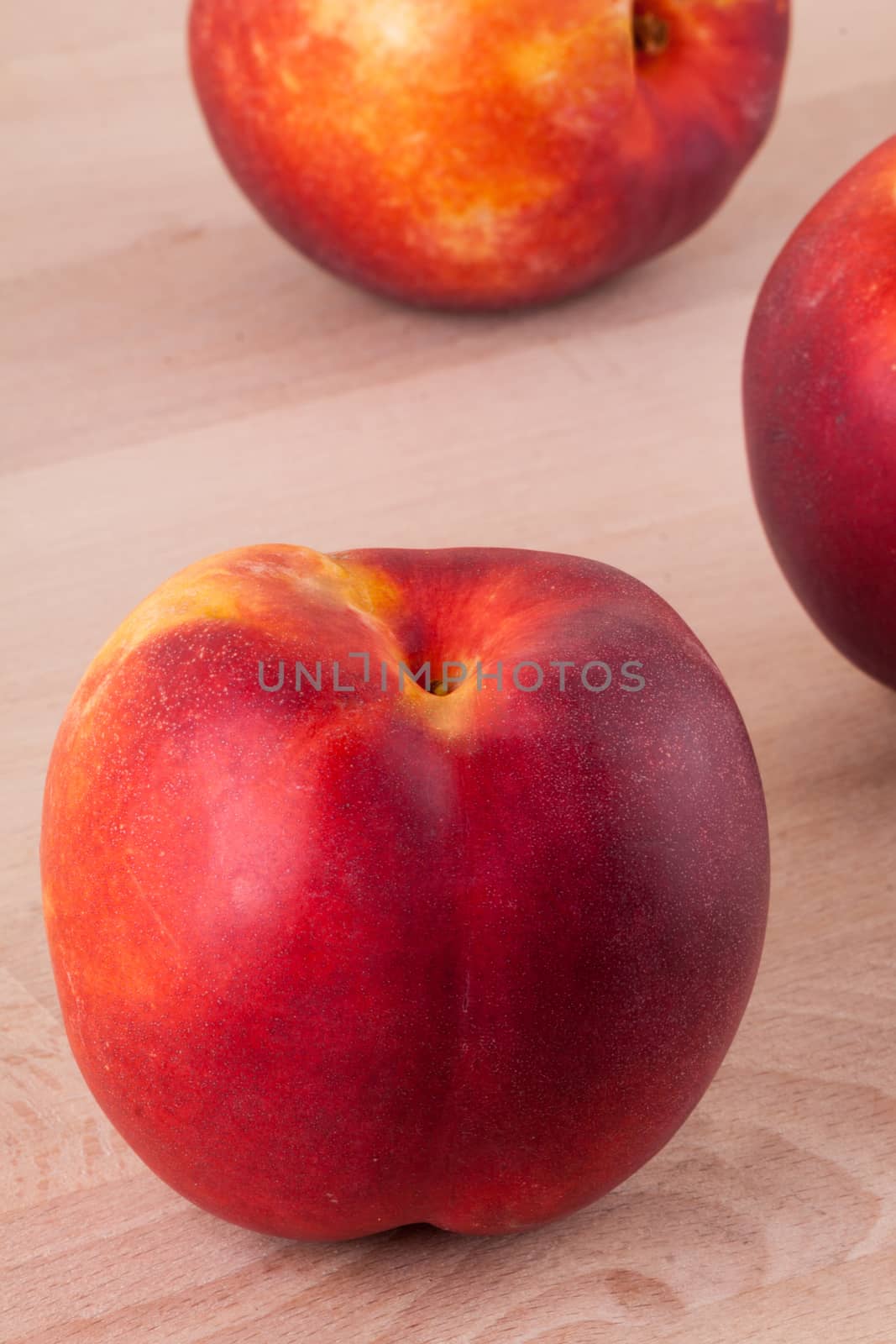 Three tasty fresh ripe juicy nectarines on white painted wooden boards for a healthy snack and diet