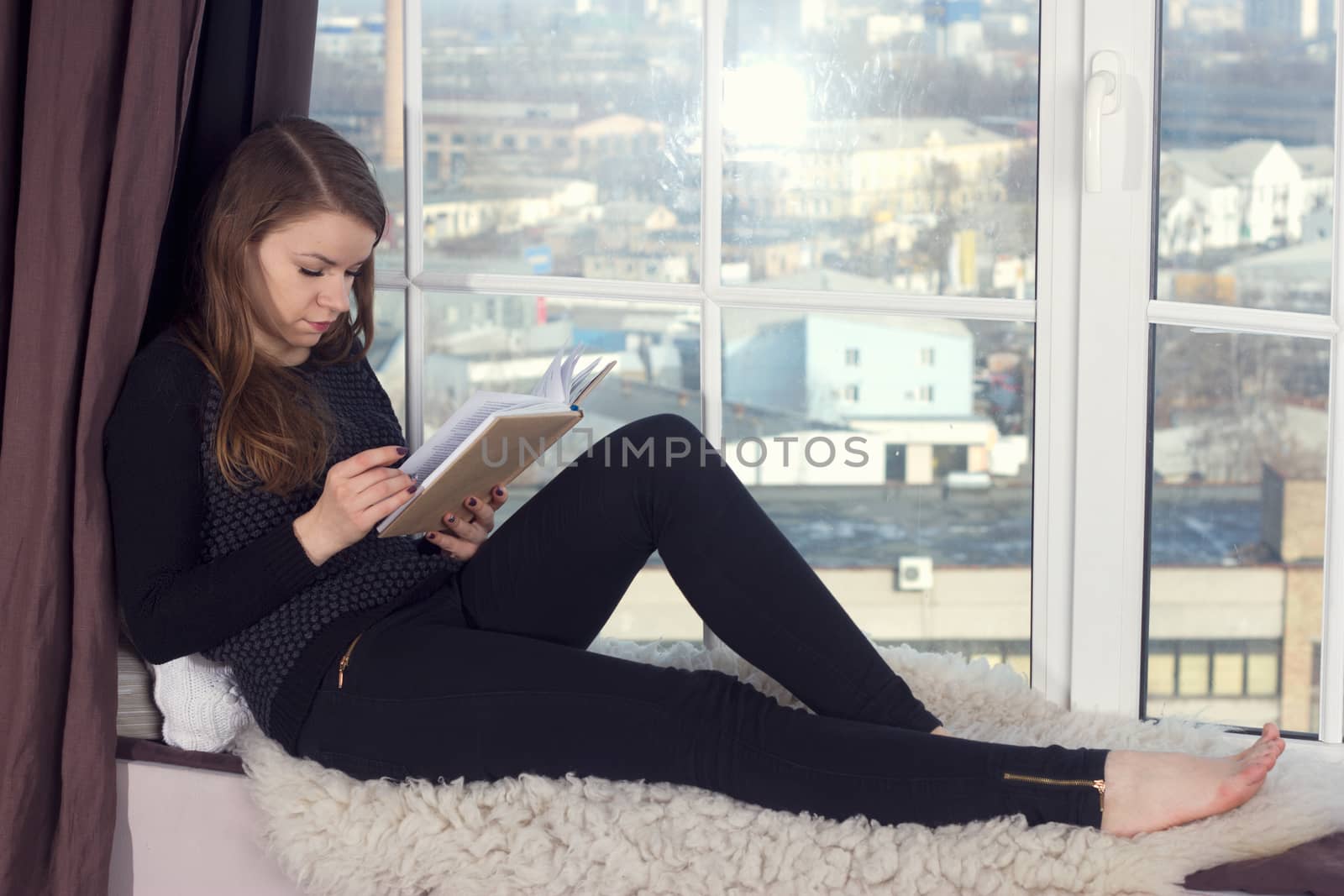 Woman studying at home and looking through the window