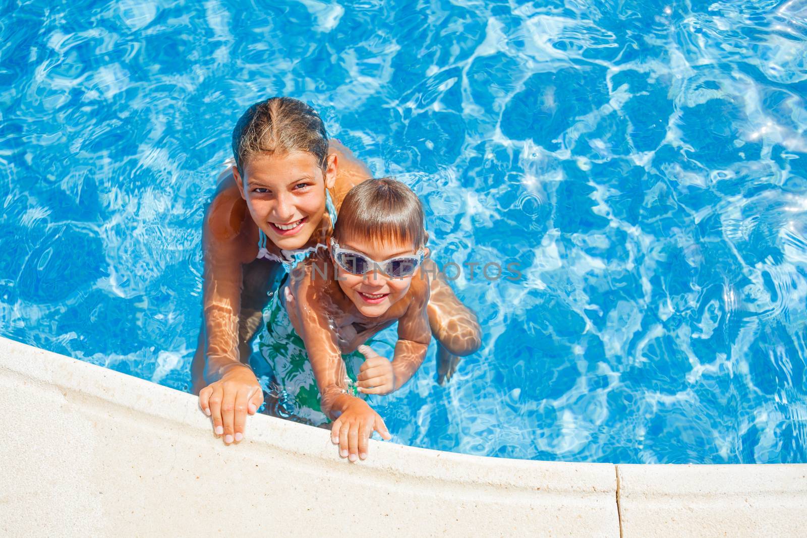 Happy kids swimming and snorking in the swimming pool