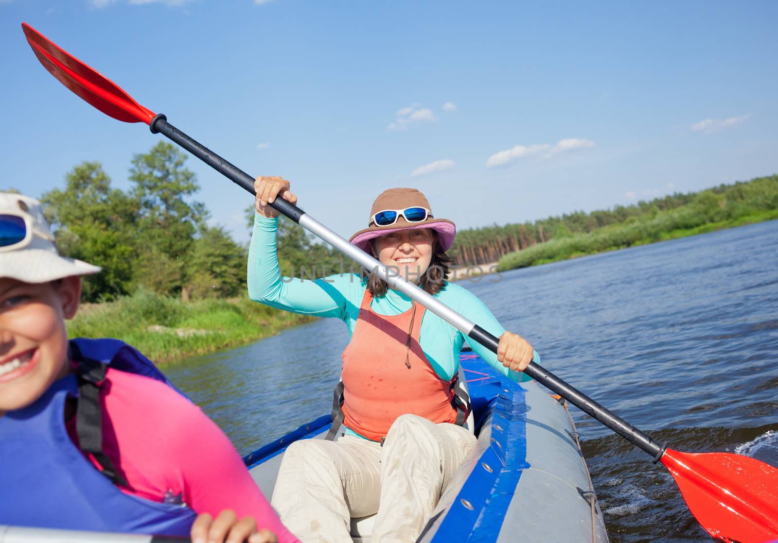 Summer vacation - Happy woman with her daughter kayaking on river.