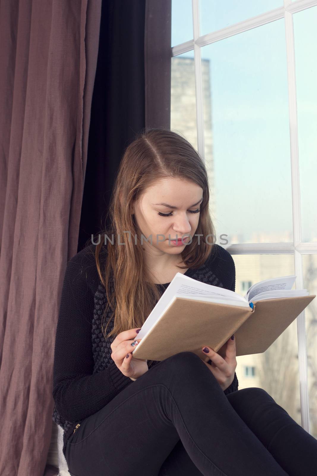 Woman studying at home and looking through the window