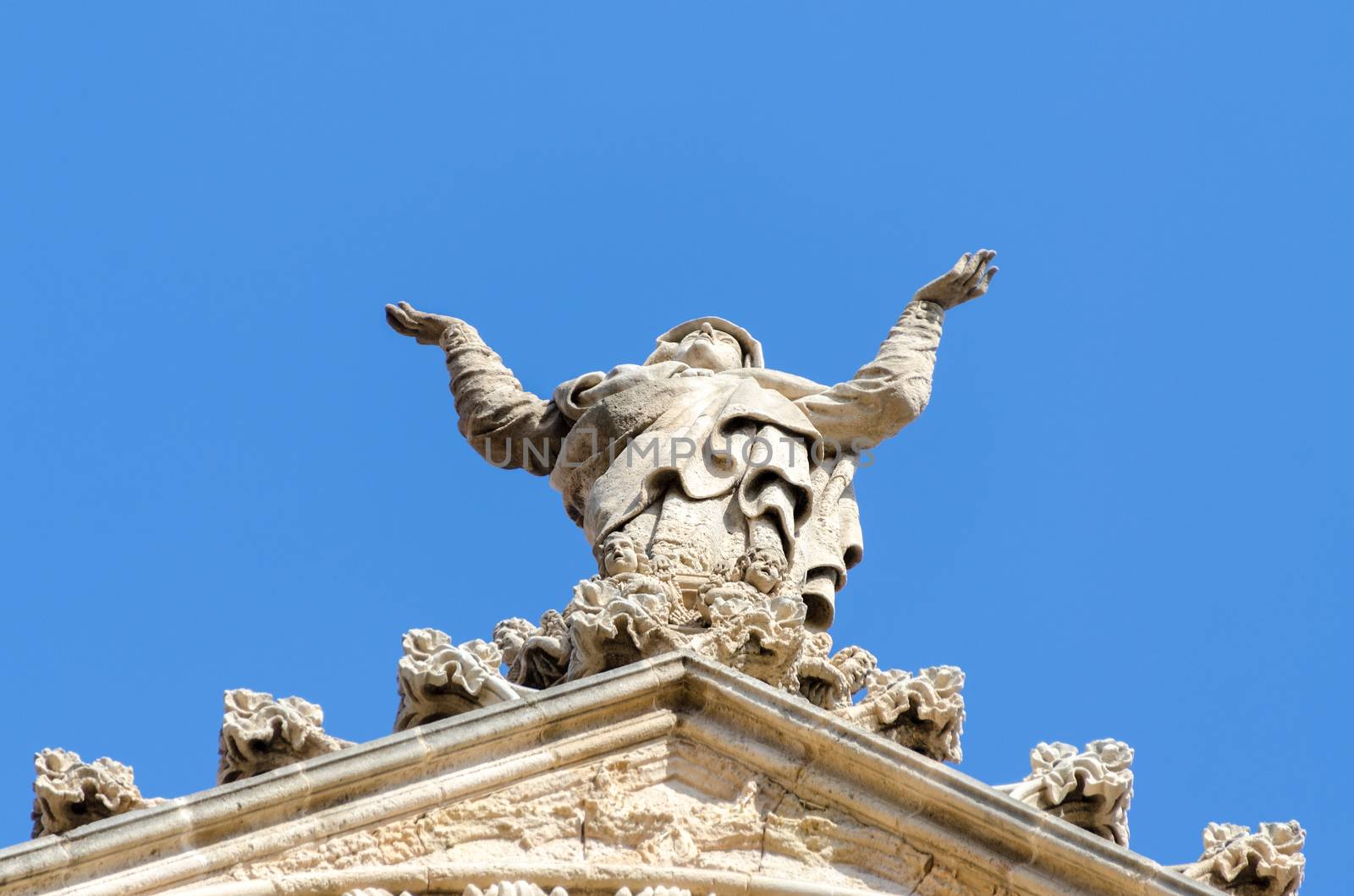 Details of roof church facade in Spain. Praying woman statue.