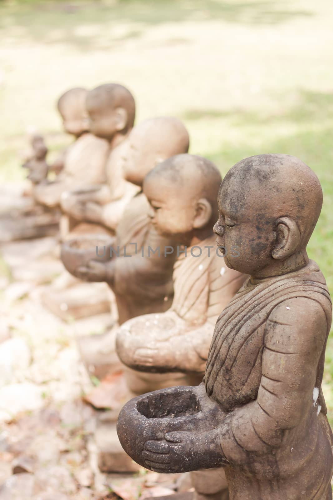 Little monk clay doll decorated in garden by punsayaporn