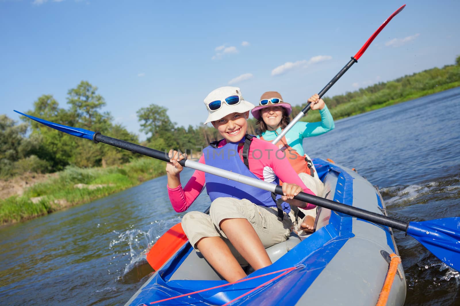 Summer vacation - Cute girl with mother kayaking on river.