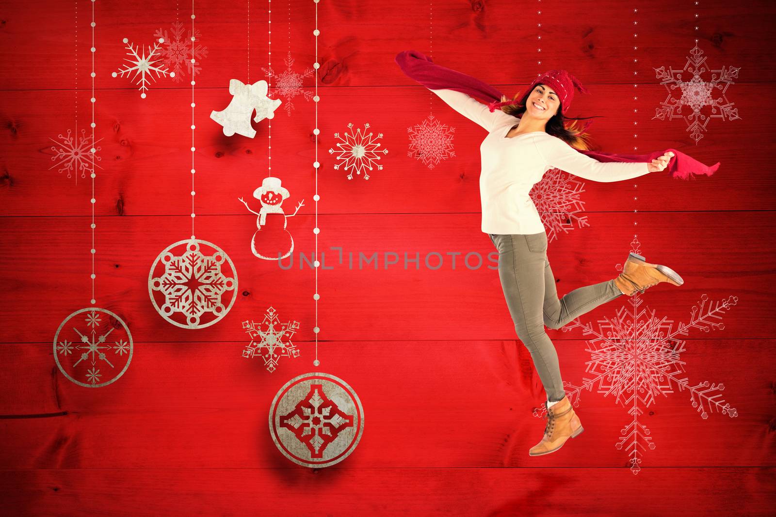 Happy brunette leaning and holding scarf against christmas decorations over wood