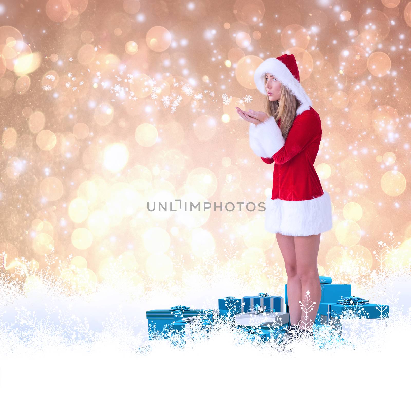 Pretty santa girl blowing over hands against yellow abstract light spot design