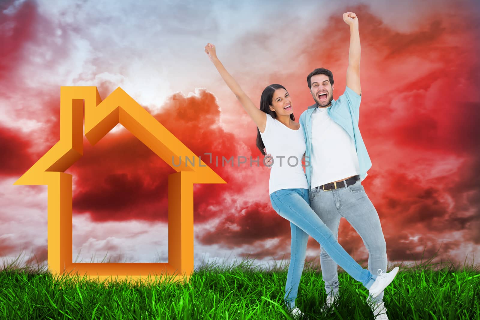 Happy casual couple cheering together against green grass under red cloudy sky
