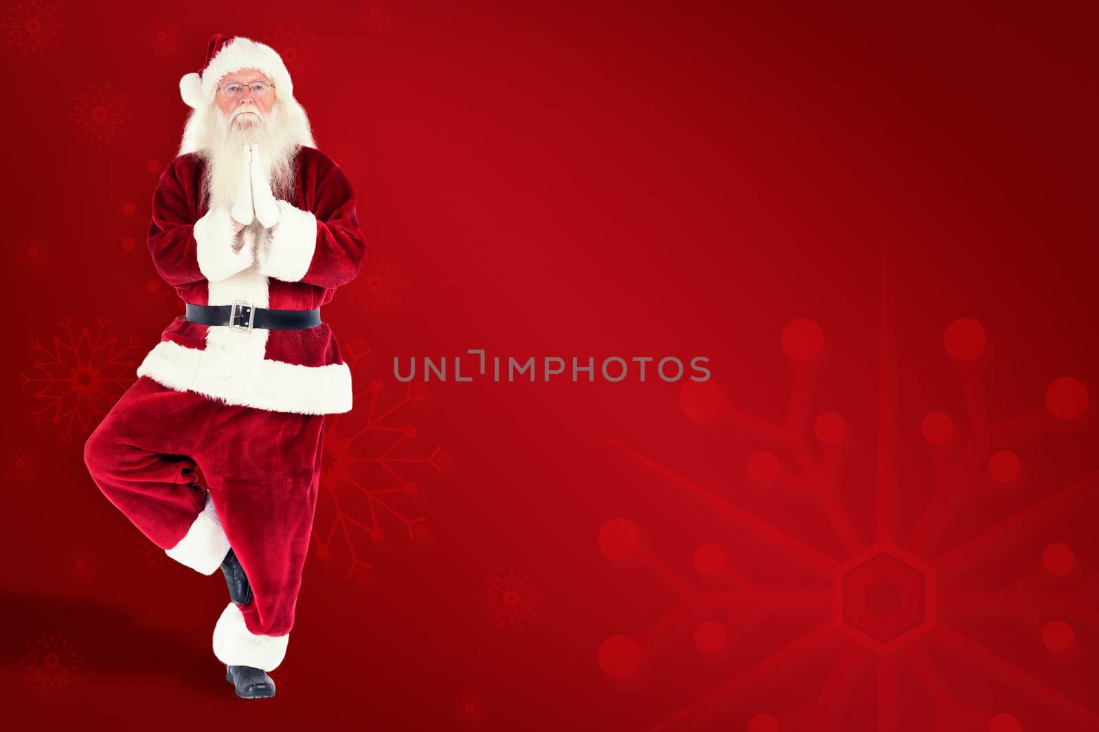 Father Christmas doing some yoga against red background