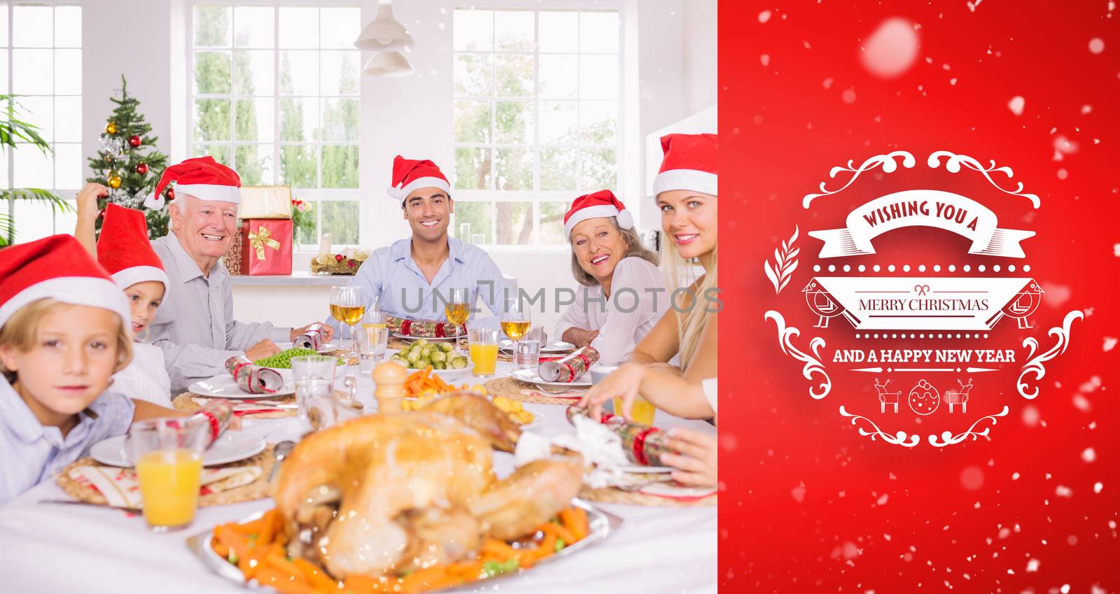 Smiling family around the dinner table at christmas against red vignette