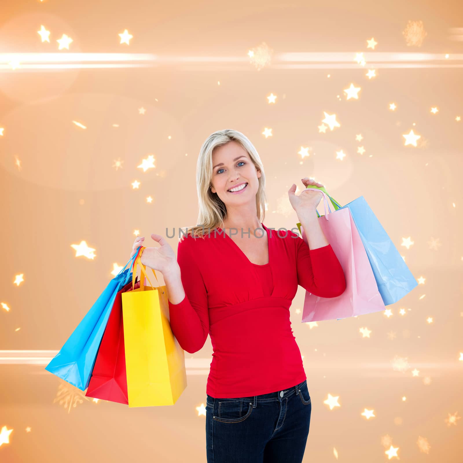 Happy blonde holding shopping bags against bright star pattern on cream