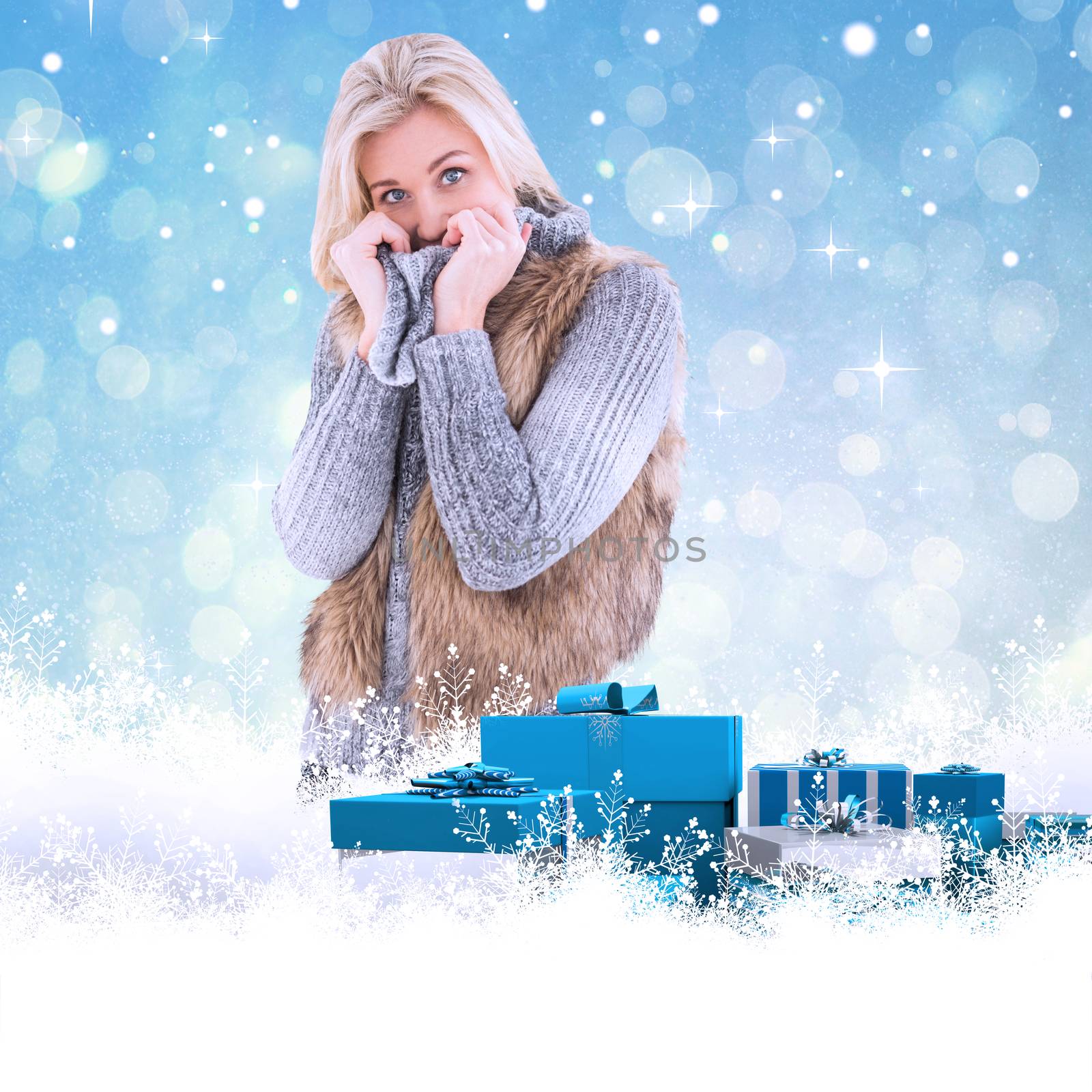 Blonde in winter clothes smiling at camera against blue abstract light spot design