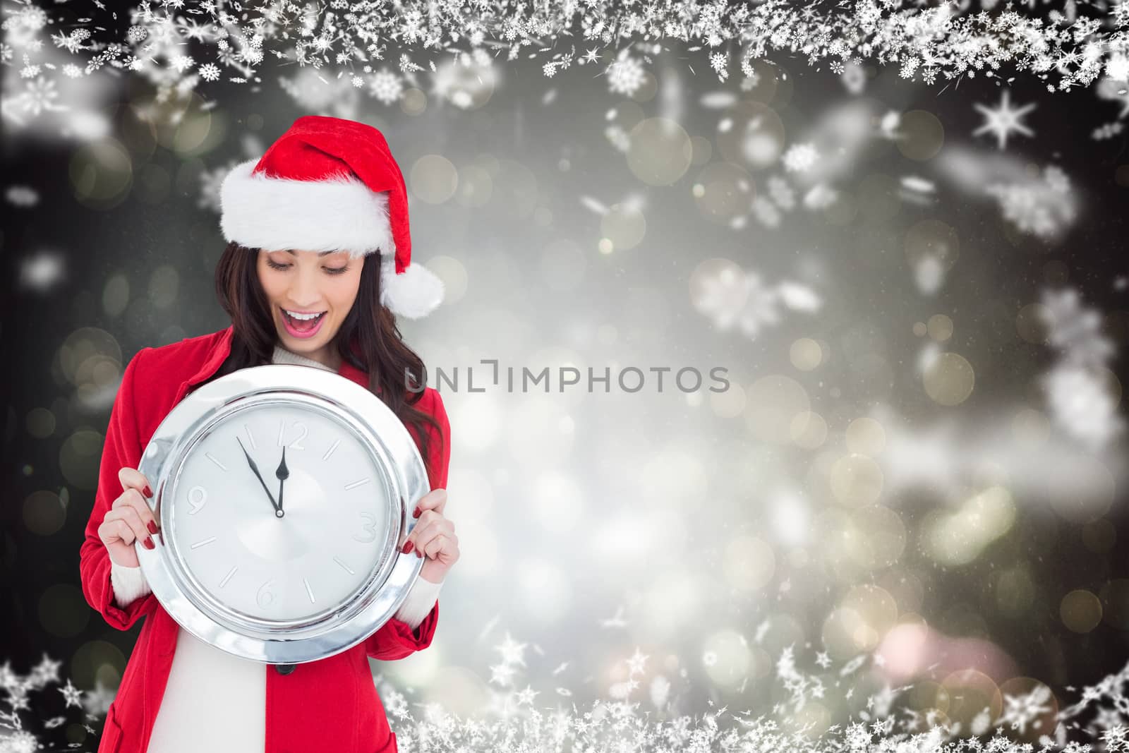 Excited brunette holding a clock against black abstract light spot design