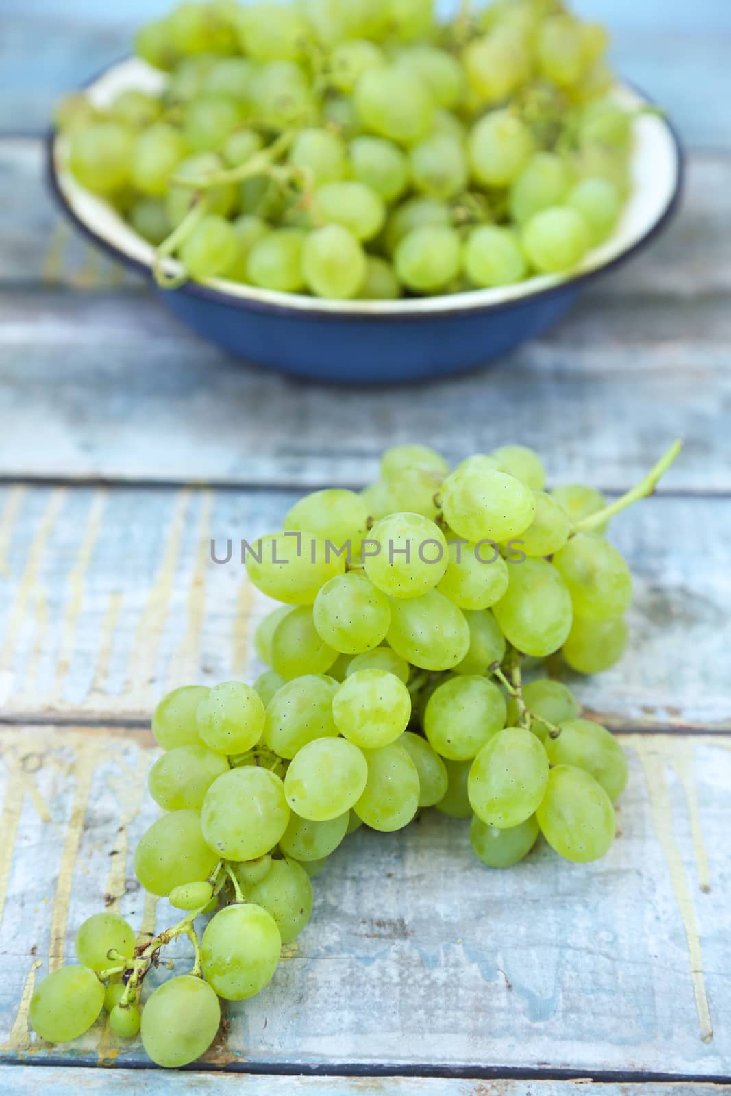 branches of fresh green grape on a wooden surface