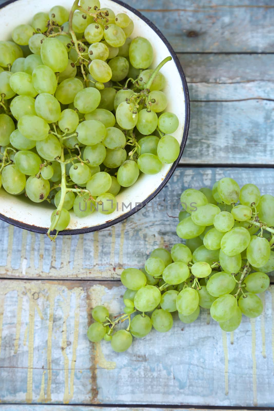 branches of fresh green grape on a wooden surface