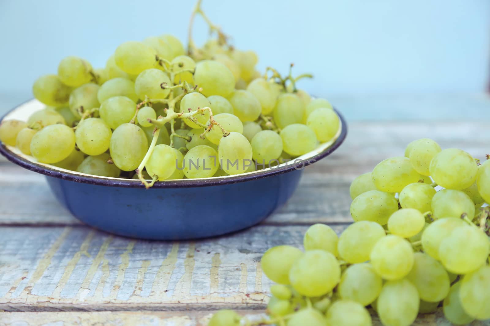 branches of fresh green grape on a wooden surface