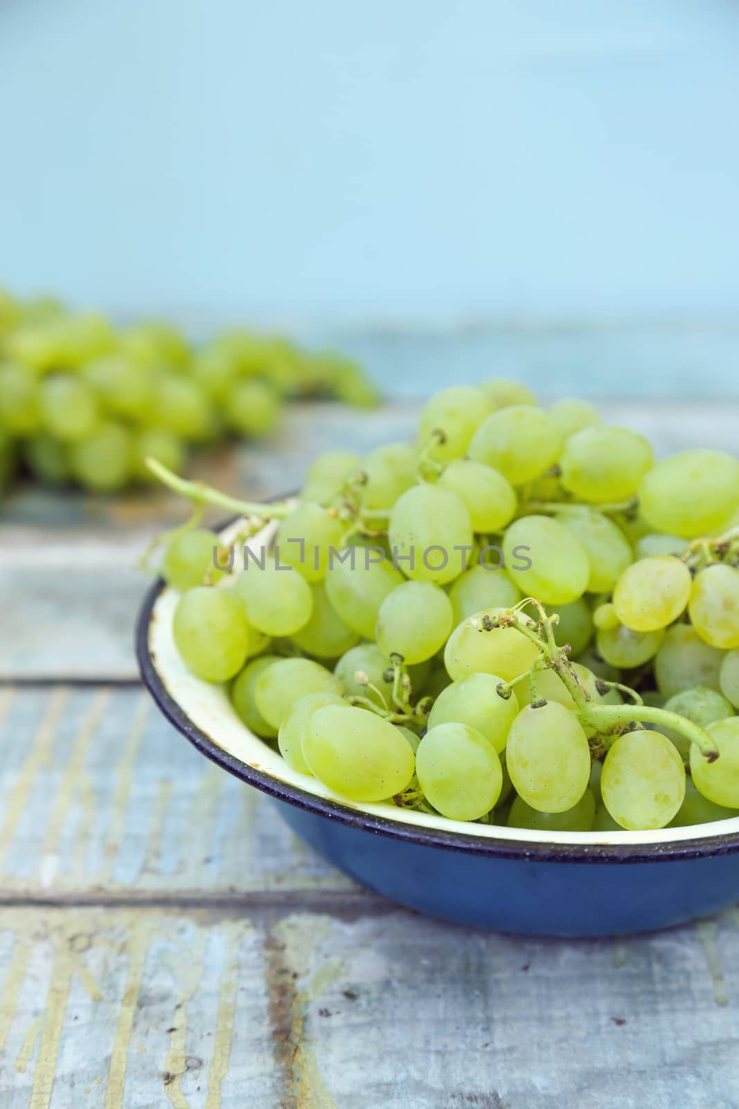 branches of fresh green grape on a wooden surface