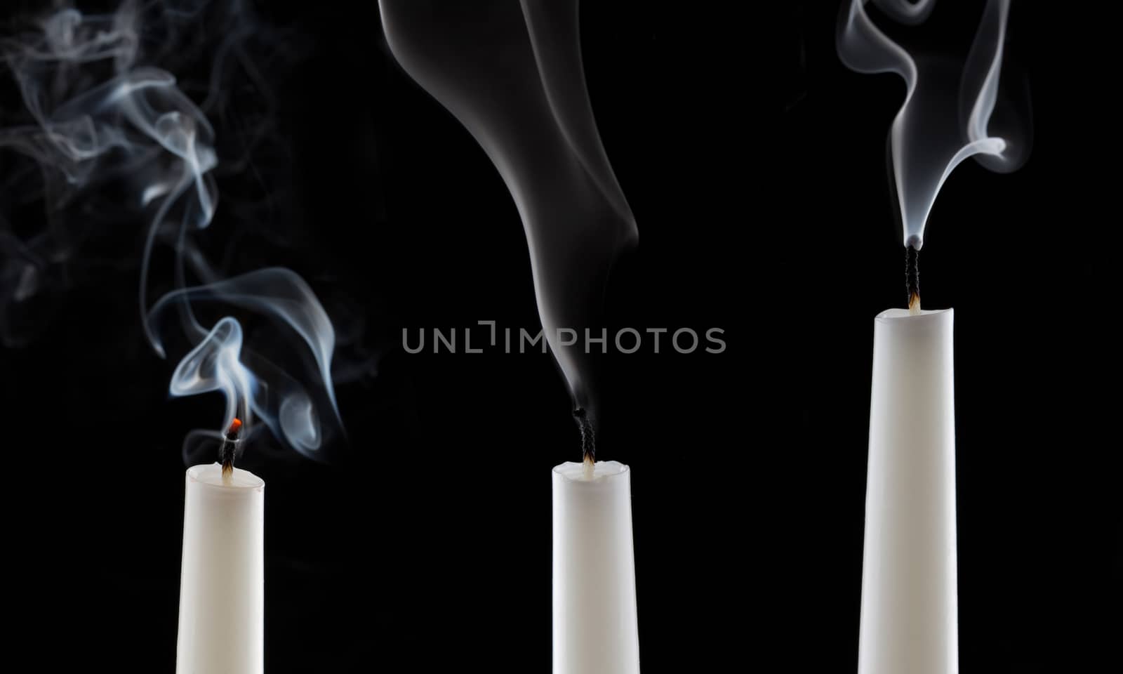 extinguished candle with smoke, isolated over black