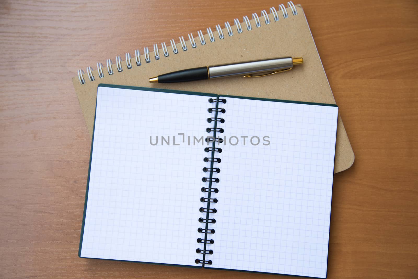 paper notebook with pen on wooden background