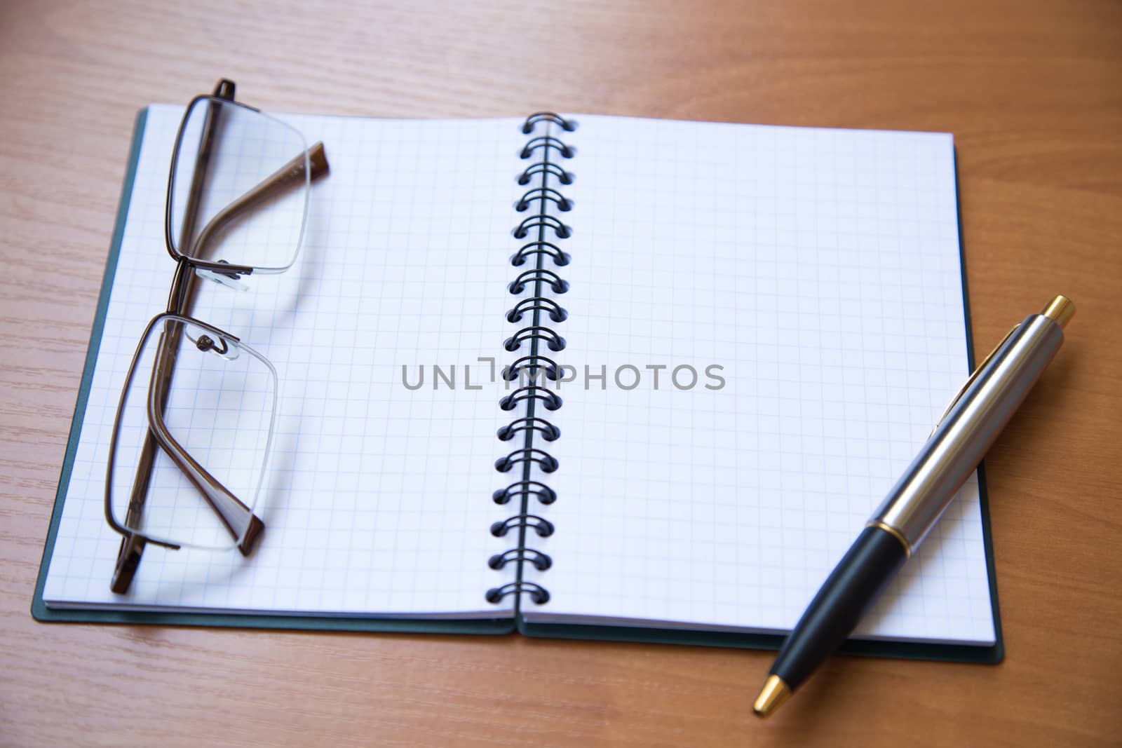paper notebook with pen on wooden background