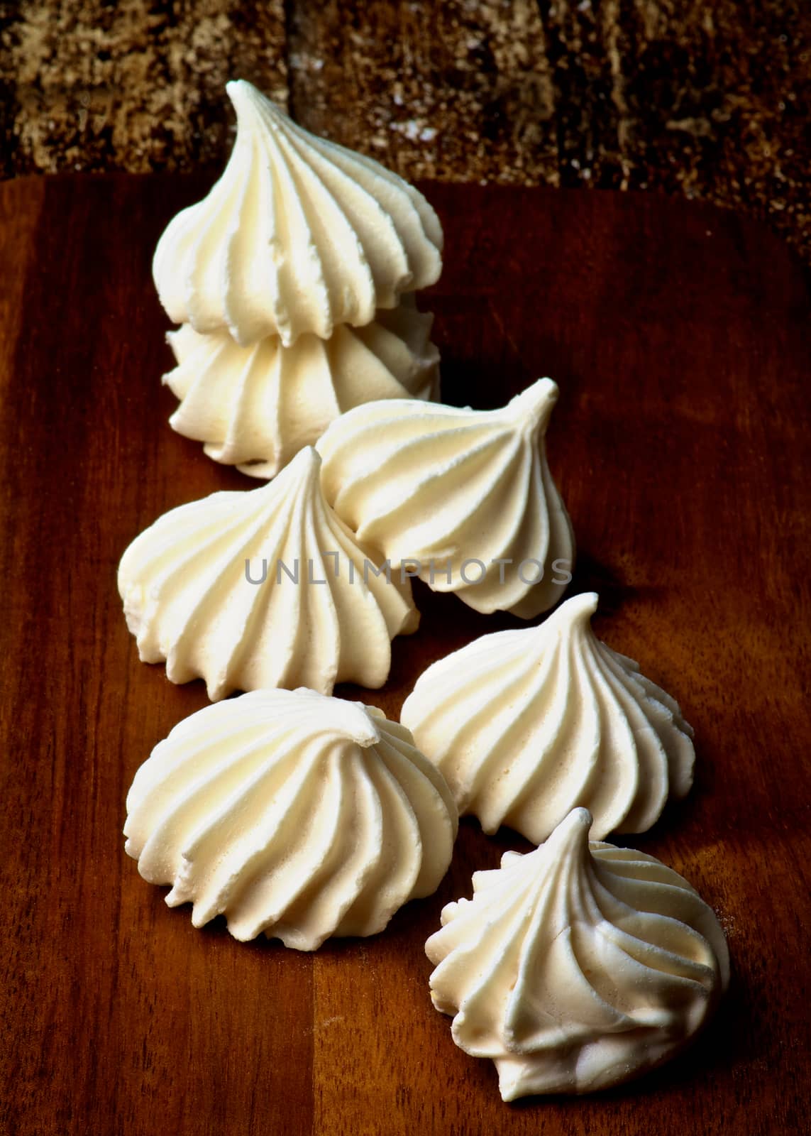 Arrangement of Vanilla Meringues Cakes In a Row on Wooden Background