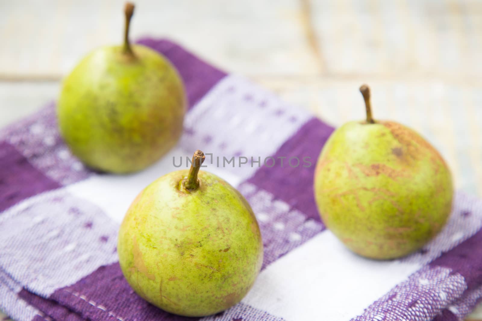 few fresh ripe pears are on a wooden surface