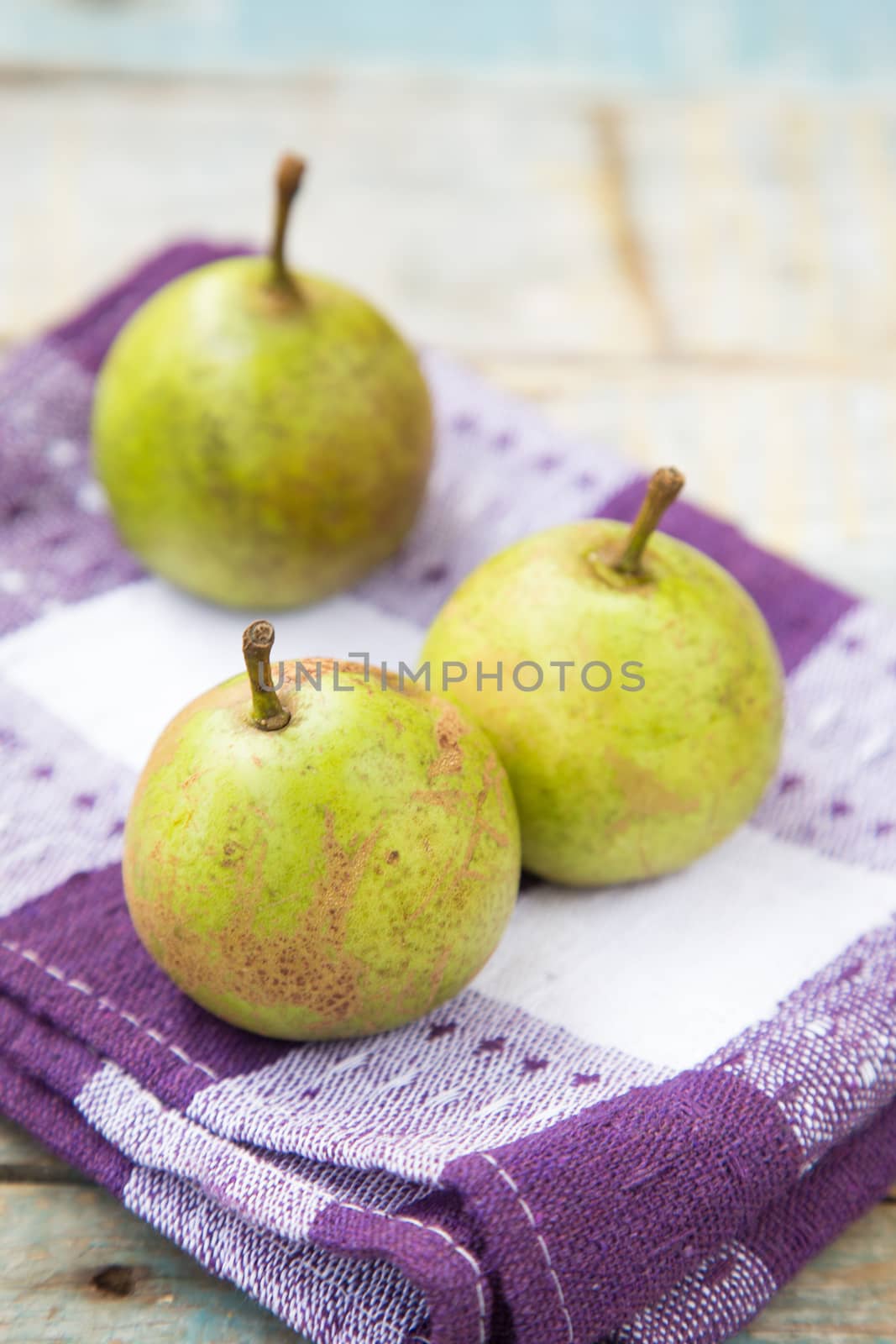 few fresh ripe pears are on a wooden surface