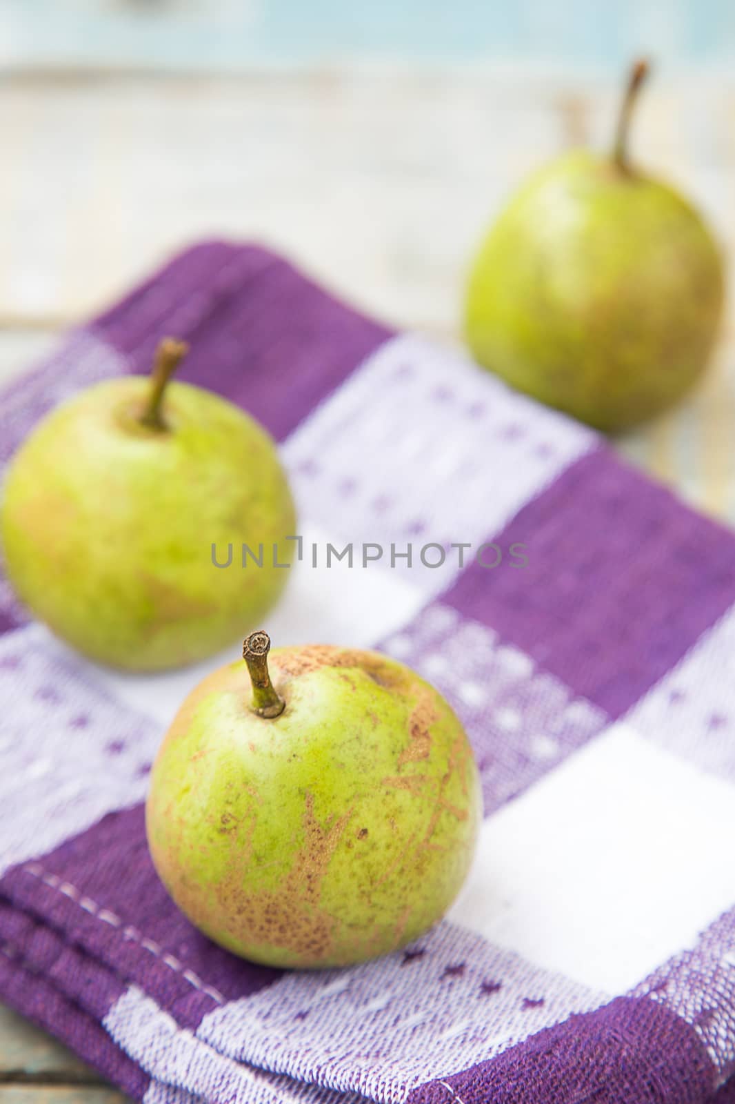 few fresh ripe pears are on a wooden surface

