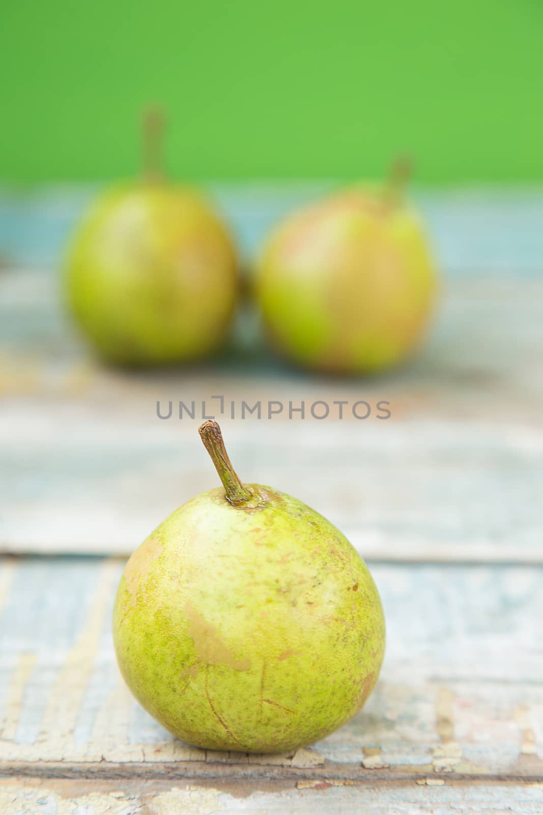 few fresh ripe pears are on a wooden surface