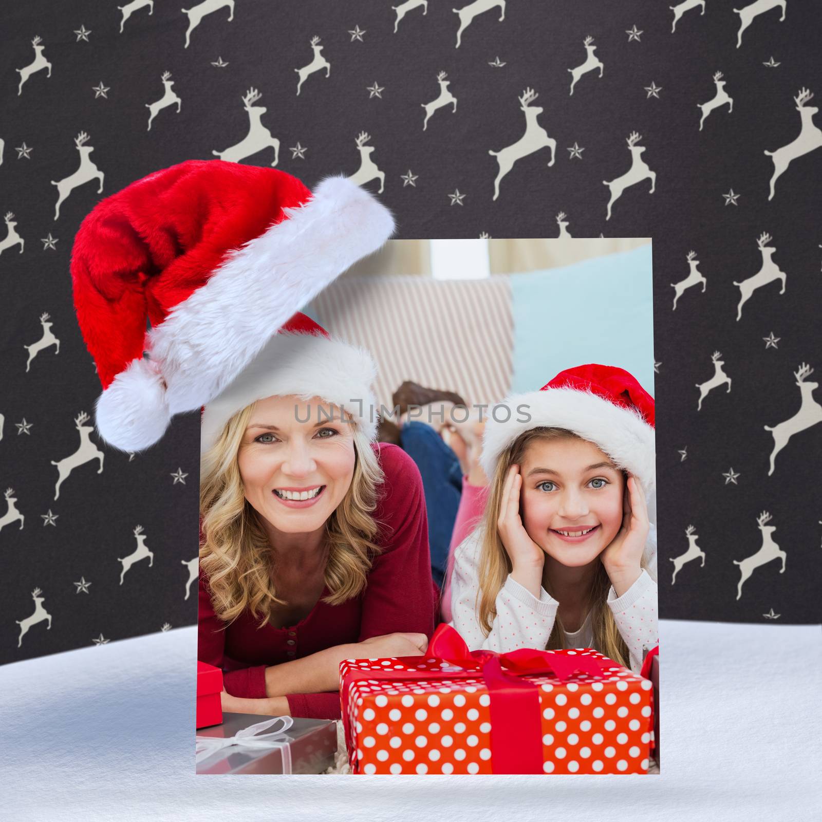 Festive little girl with mother surrounded by gifts against grey reindeer pattern