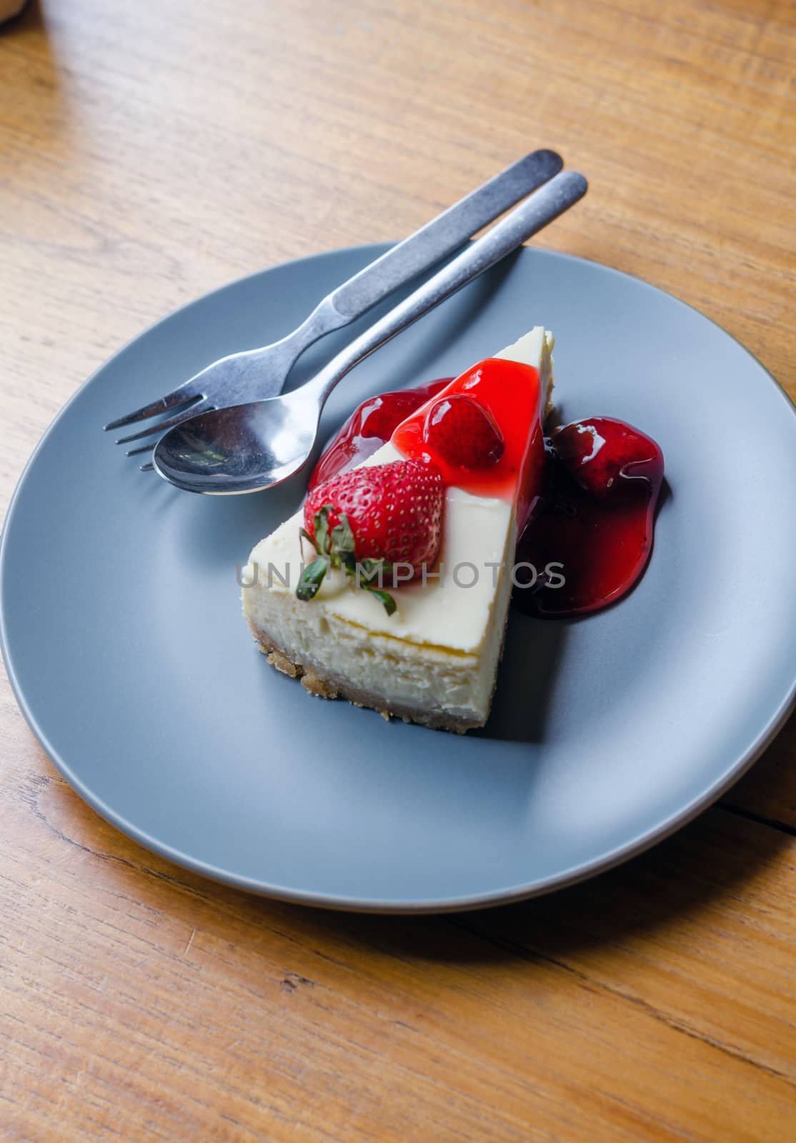 Top view of Strawberry Cheesecake with spoon and fork on wooden table