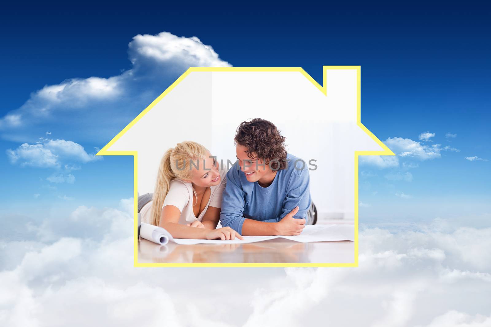 Smiling couple moving in a new house against bright blue sky with clouds