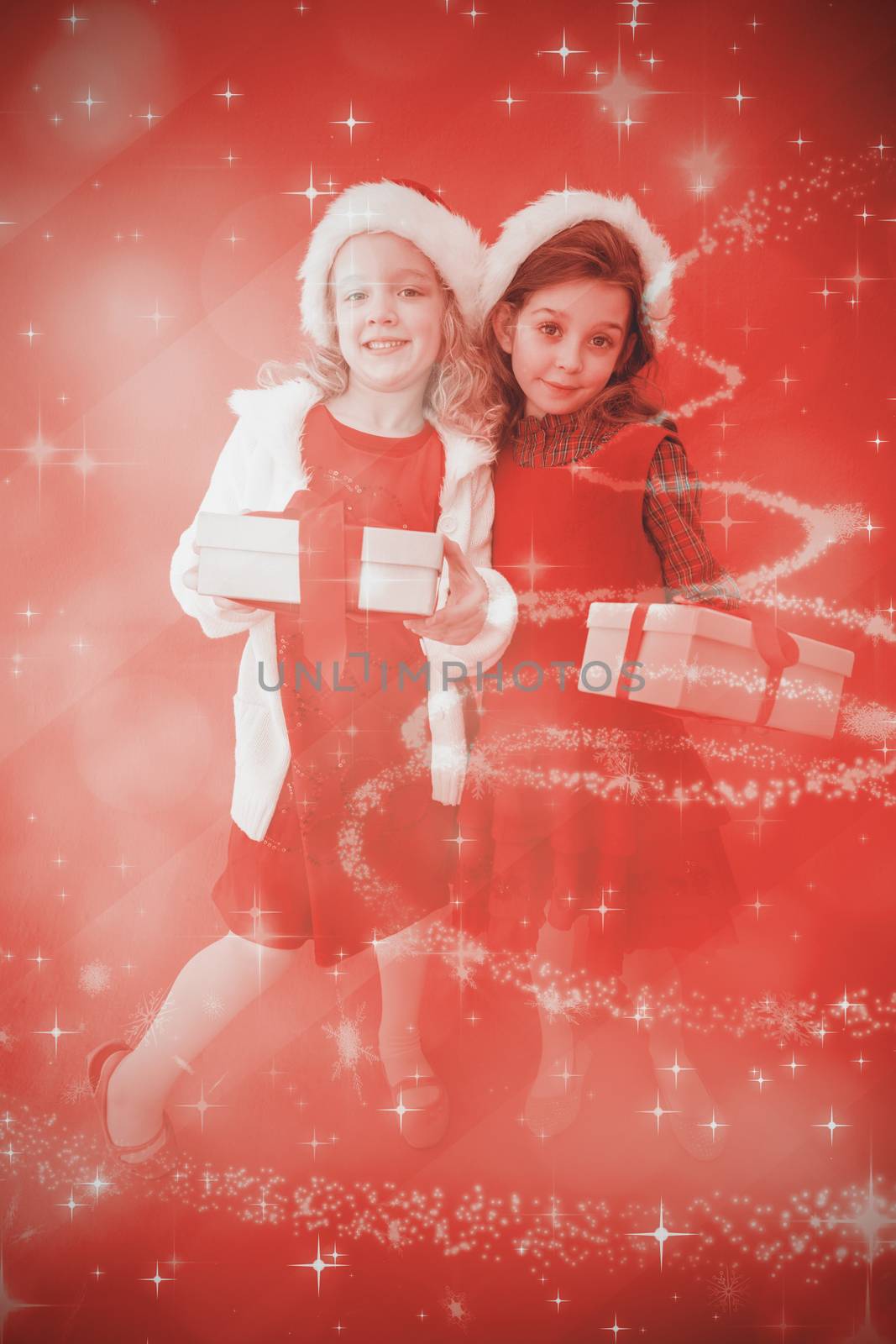 Composite image of festive little girls smiling at camera with gifts by Wavebreakmedia