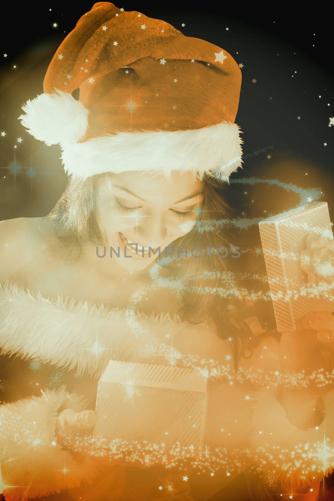 Pretty brunette in santa outfit opening gift against glittering christmas tree design