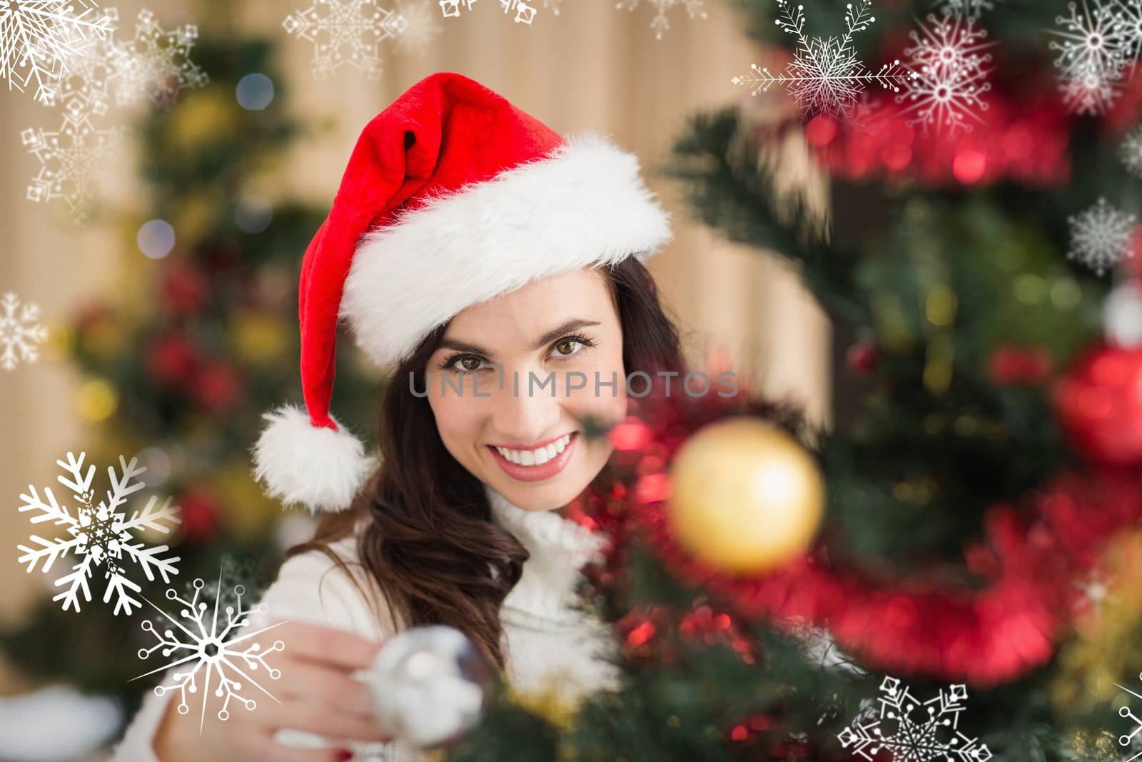 Beauty brunette decorating a christmas tree against snowflakes