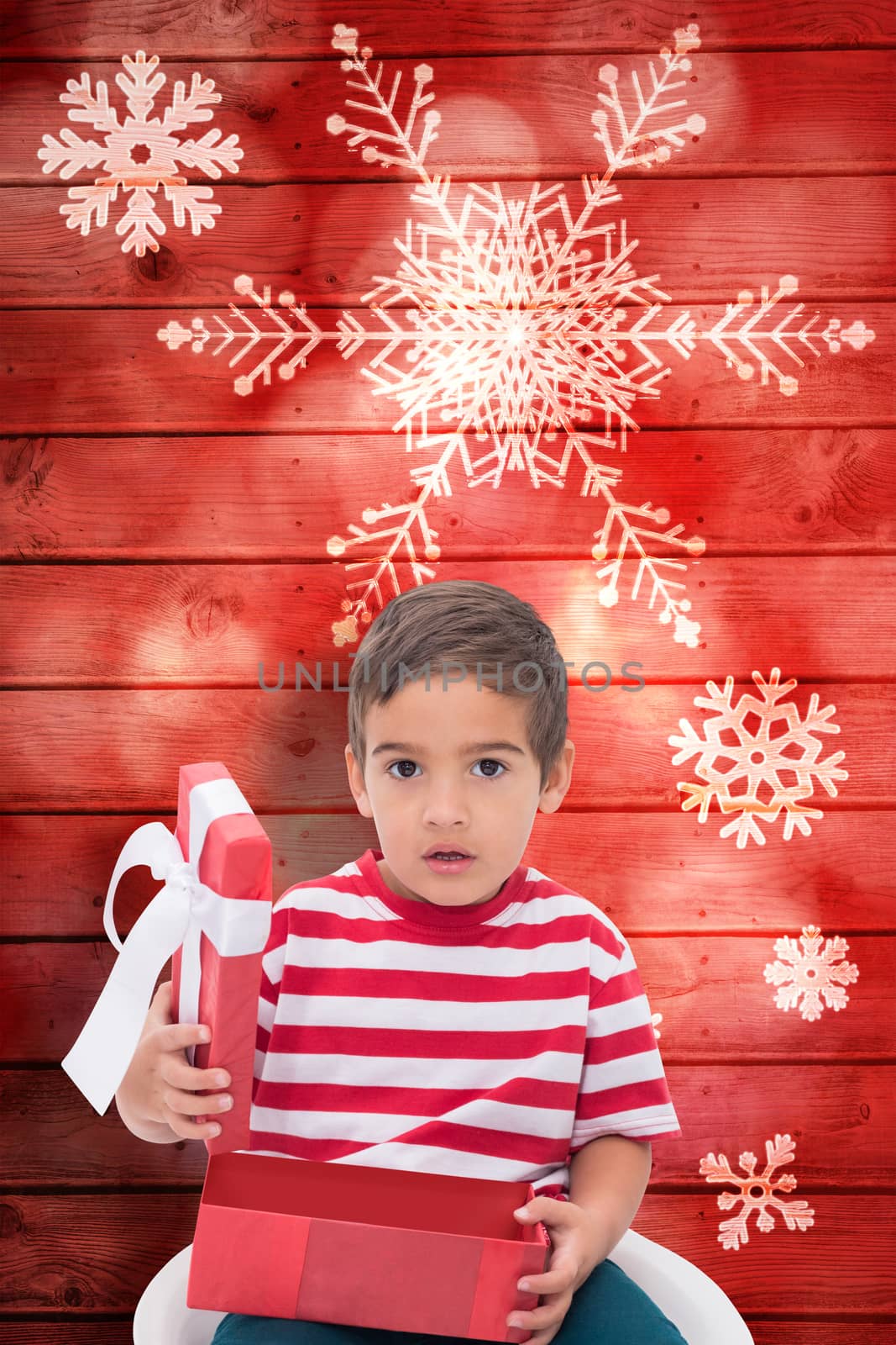 Composite image of cute little boy opening gift by Wavebreakmedia