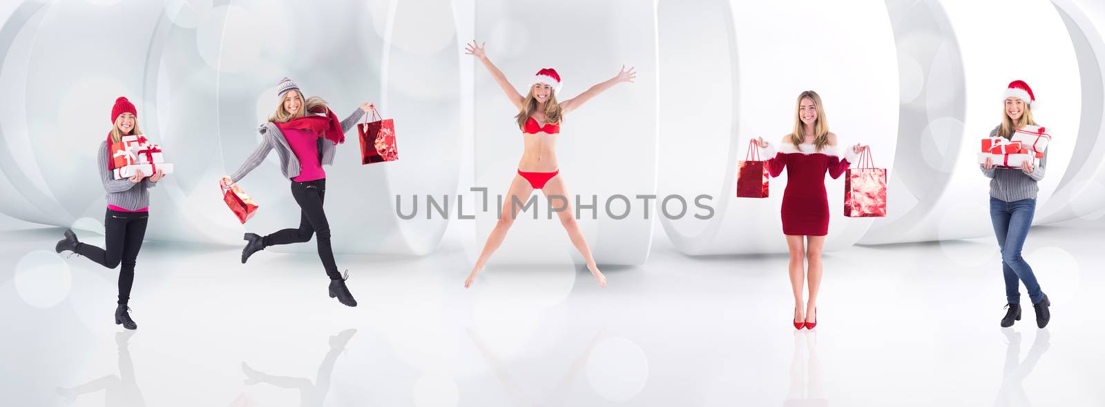 Festive blonde holding pile of gifts against lights twinkling in modern room