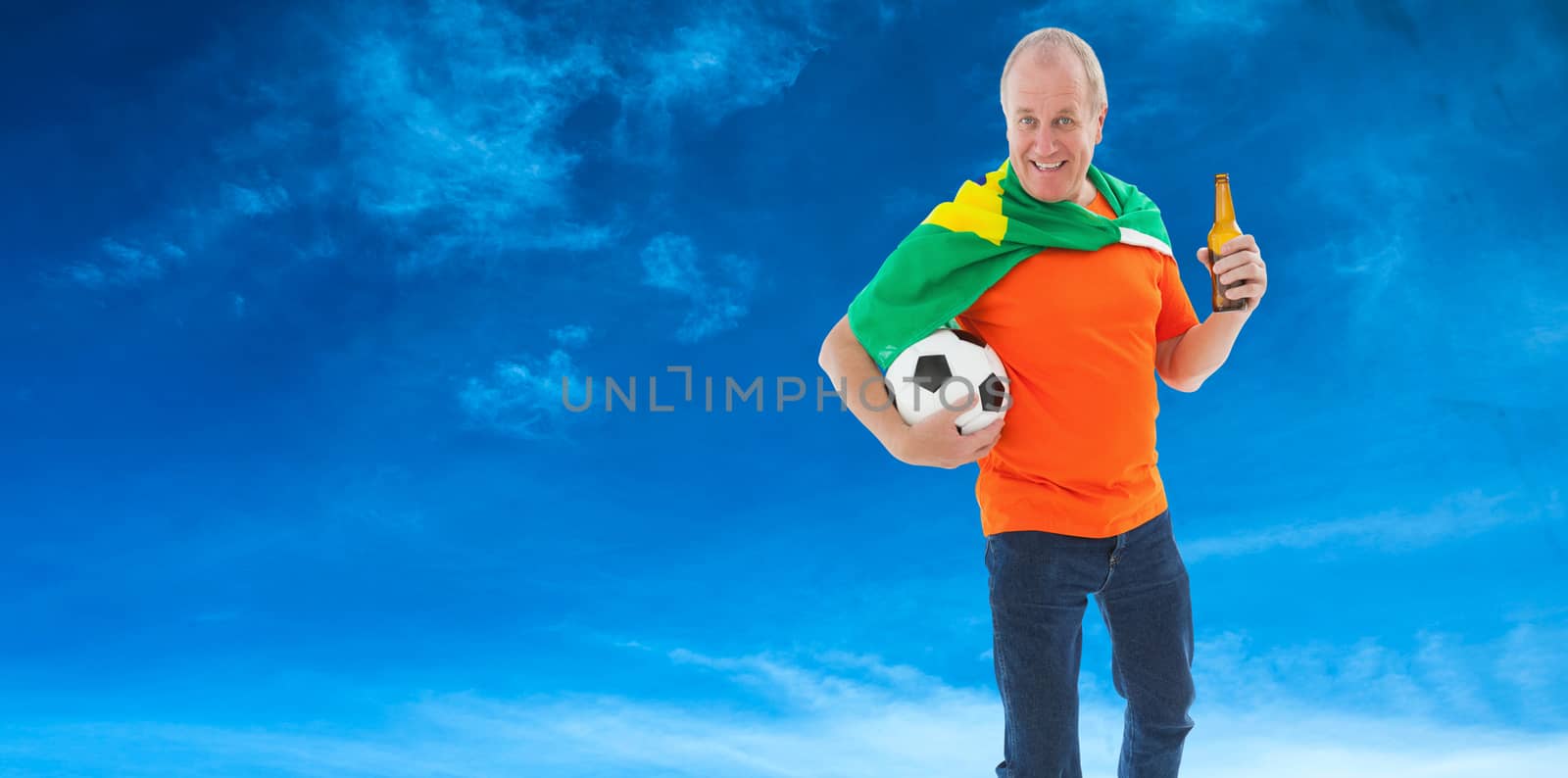 Composite image of mature man in orange tshirt holding football and beer by Wavebreakmedia