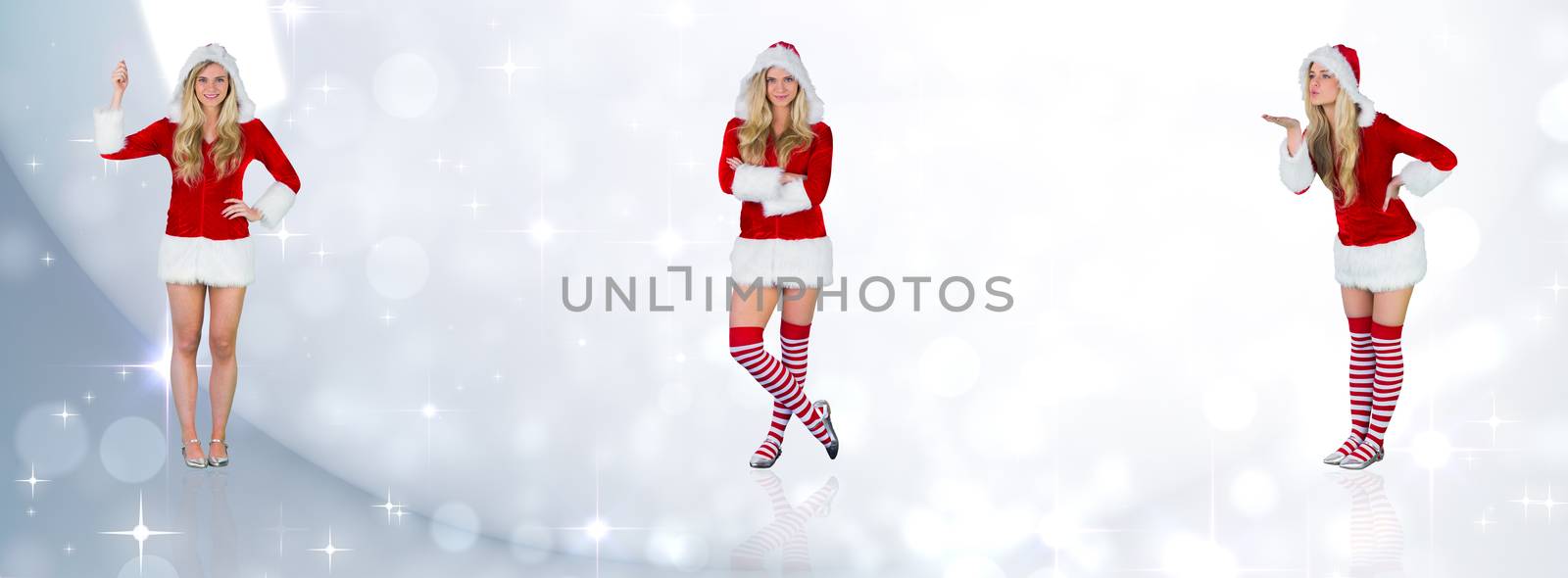 Pretty girl in santa outfit holding hand up against lights twinkling in room