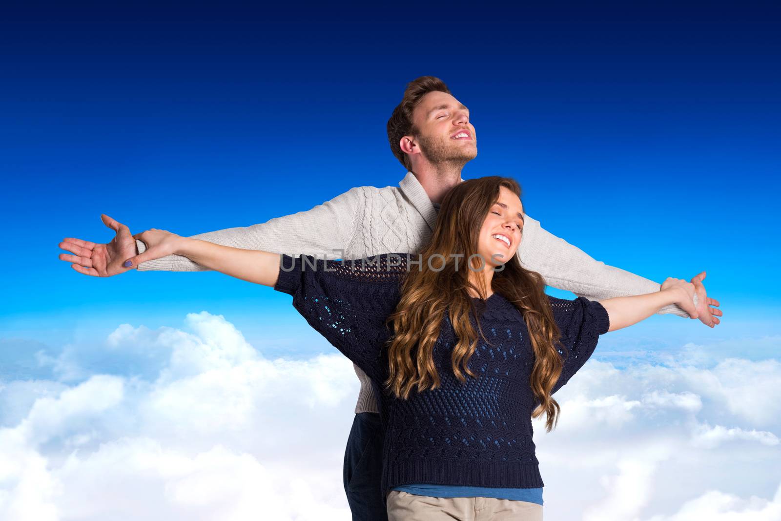Composite image of romantic young couple with arms out by Wavebreakmedia