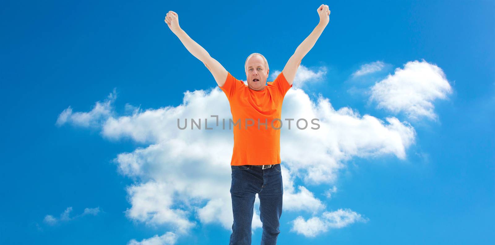 Composite image of mature man in orange tshirt cheering by Wavebreakmedia