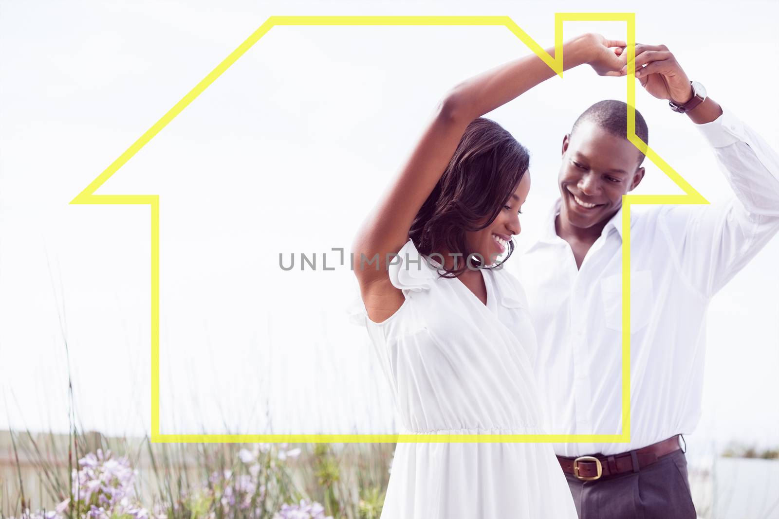 Romantic couple dancing and smiling against house outline